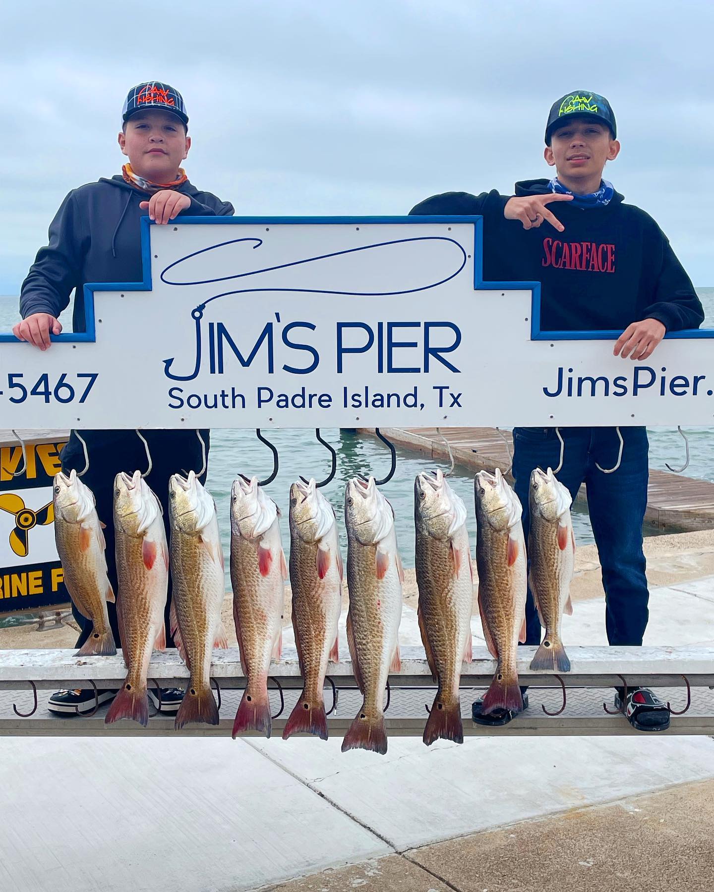 Young angler smiling and holding a fish at Jim's Pier