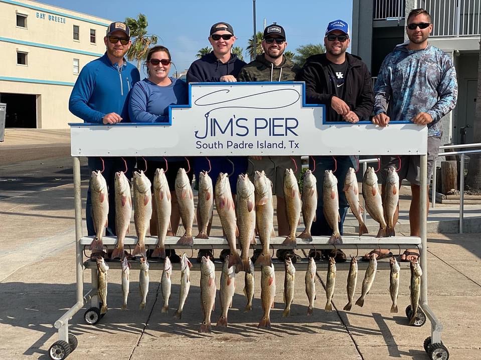 Group of anglers at the pier showing off their catches