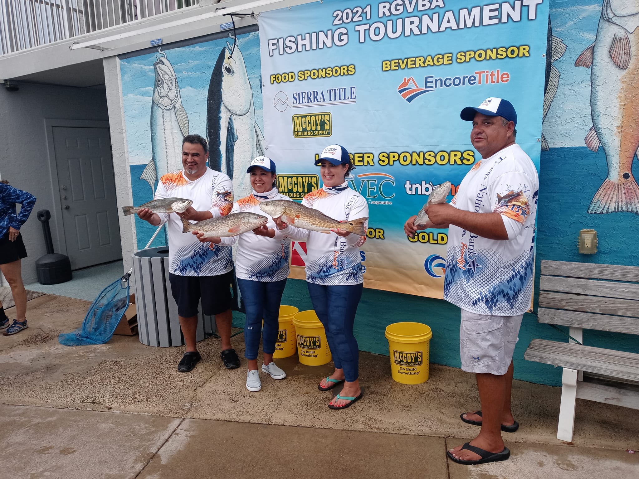 Local tournament participants holding fish near the pier